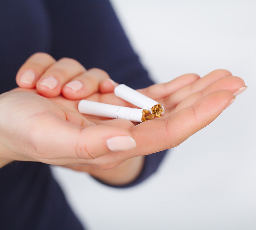 A picture of a person holding broken cigarettes in his palm.