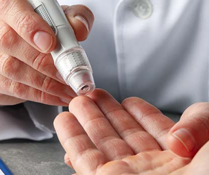 A picture of a doctor measuring his patient's diabetes with a monitoring device.