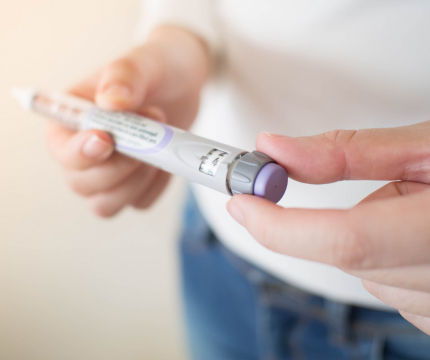 This image depicts a man holding a hand Essential-Insulin.