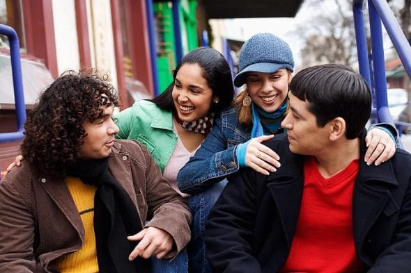 An image showing a group of people engaged in conversation and smiling.