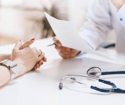 An Image of a doctor conducting routine diabetes health checkups, explaining to the patient, with a stethoscope placed on a table.