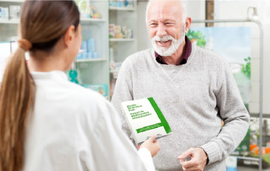 An image shows, doctor giving a Pharmacy book to an older man.