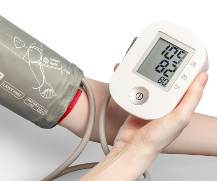 Blood pressure device wrapped around arm with digital monitor in other hand